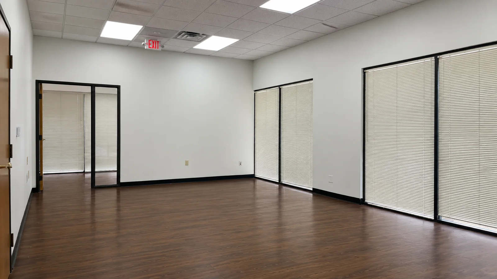 Large open room in Suite 100B with fresh paint, LED panel lights and windows along one wall